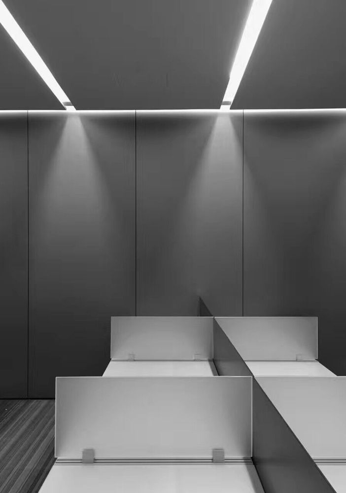 天花以石膏板为主,覆盖大部分空间,线性灯槽集成了空调的出风口,吊顶