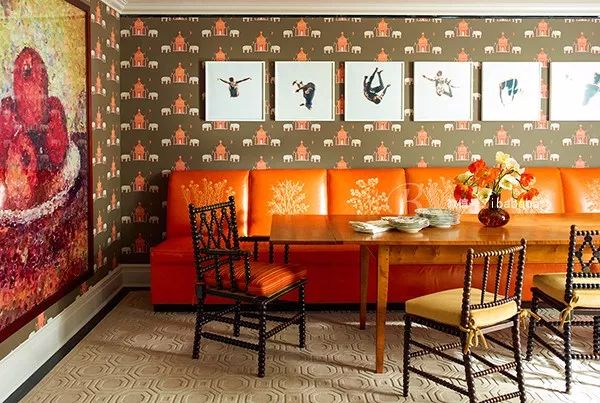 爱马仕橙色的多人沙发排列在餐桌一旁,同色的窗帘也在光线的照耀下