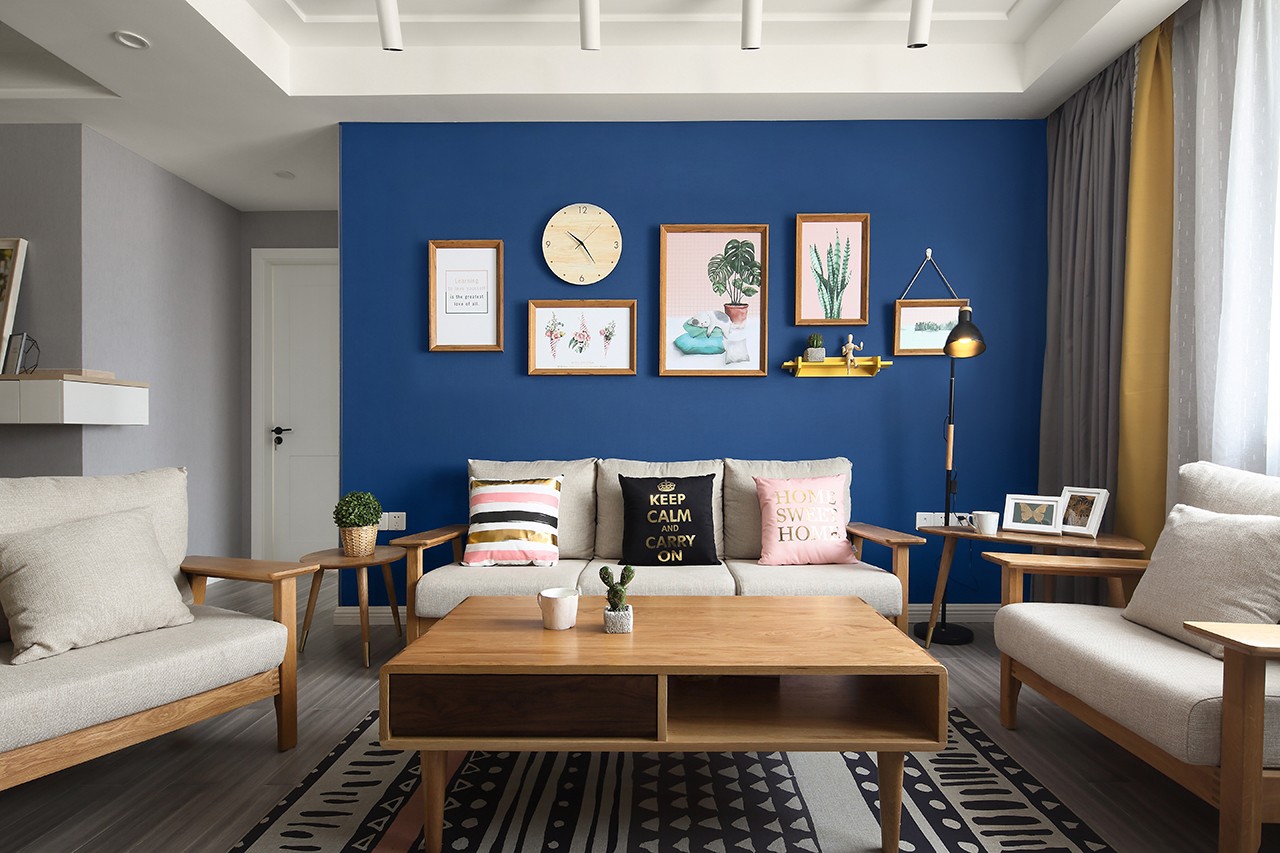 原木色布艺沙发撞色深蓝色墙布的背景,突出木作家居给予空间的原生态