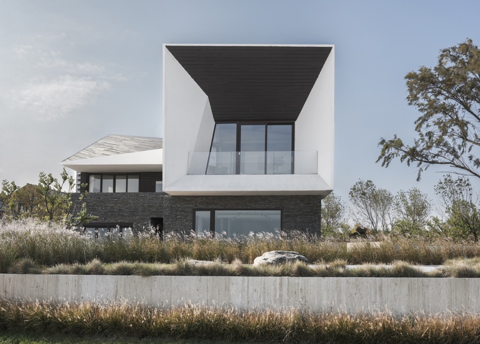 厚重的"t"型白色混凝土墙坐落于深色片岩基座之上,秦皇岛临海t宅